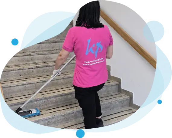 Frau in pinkem T-Shirt mit KP Gebäudereinigung GmbH Logo wischt eine Treppe in München